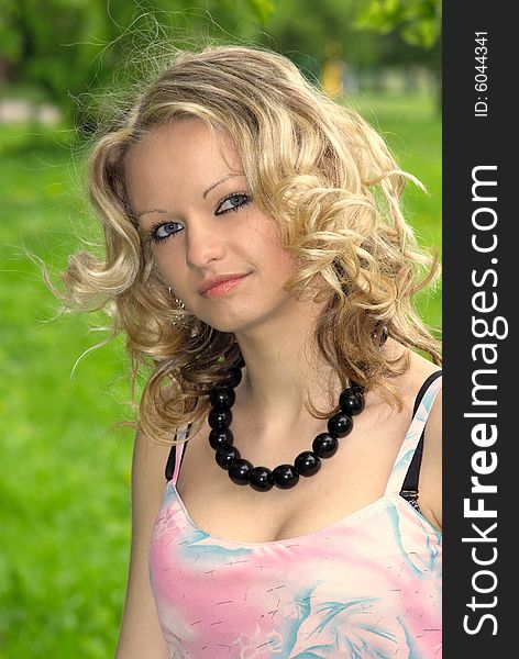 Beautiful girl with black necklace at summer