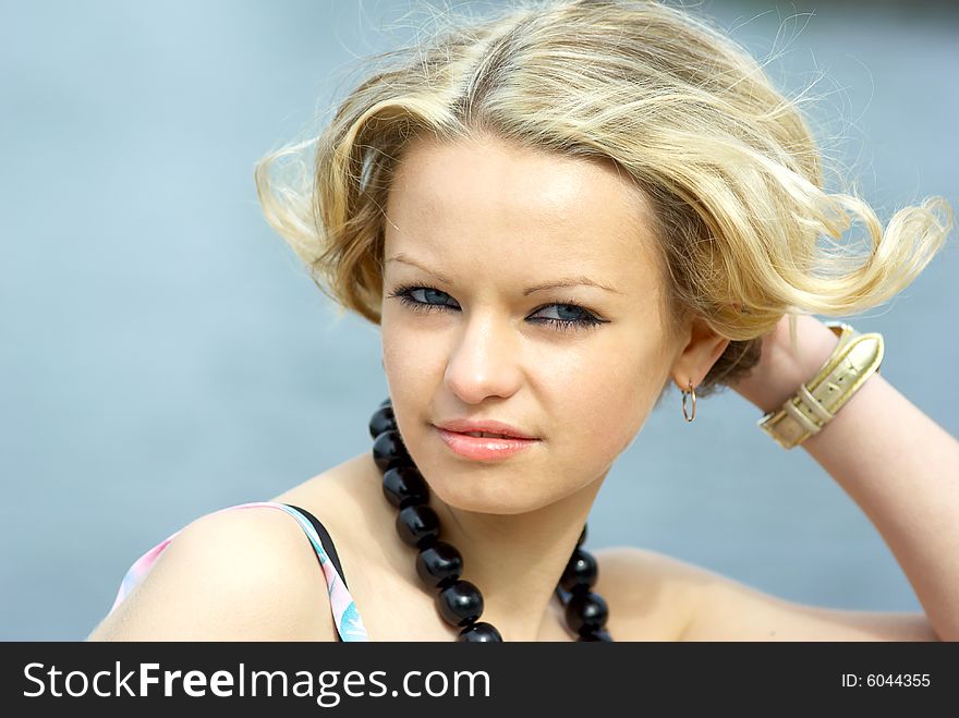 Beautiful girl with black necklace at summer