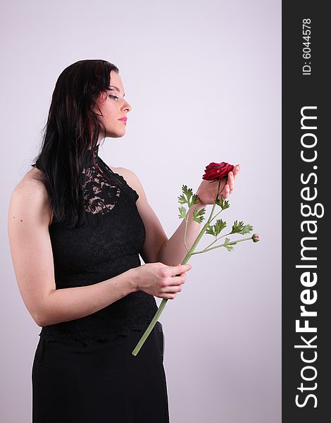 Beautiful young woman holding a rose, studio photo. Beautiful young woman holding a rose, studio photo