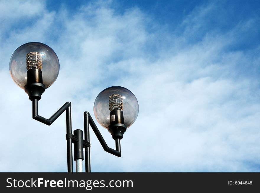 Lamppost against blue cloudy sky