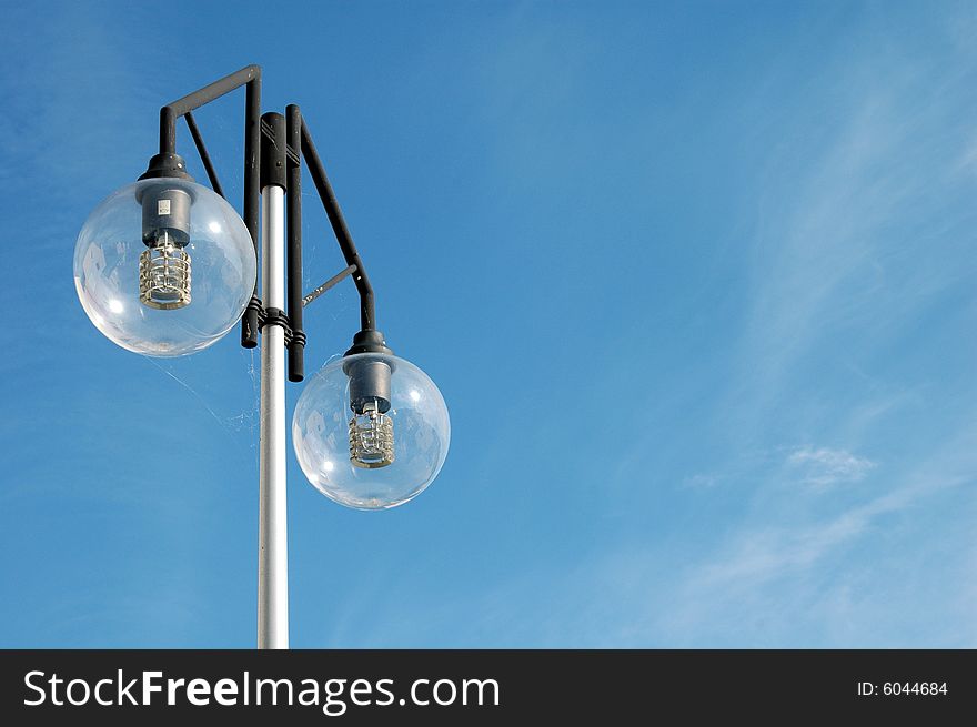 Lamppost against blue cloudy sky