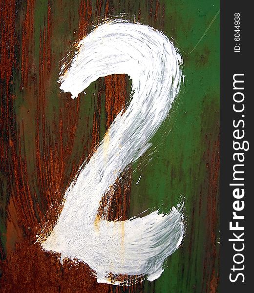 The figure two is drawn by a white paint  on a rusty metal background.