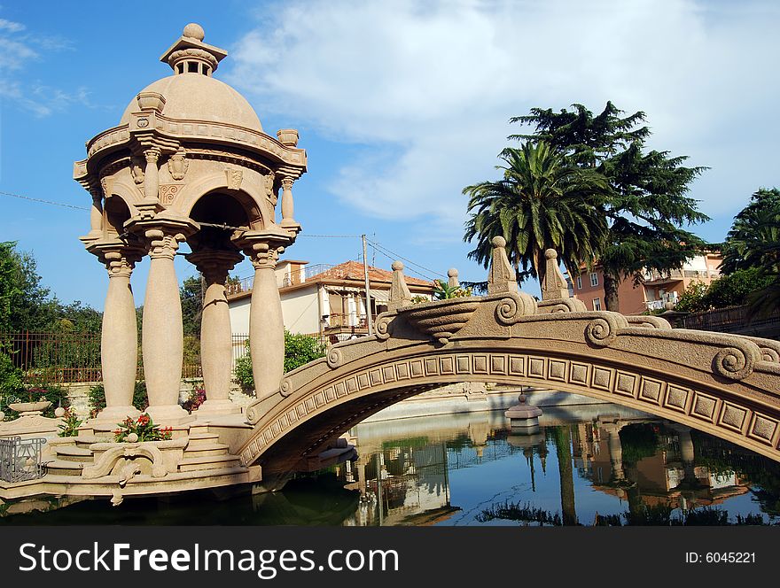 The fishpond with a bridge and a small temple in the park of Grock's Villa in Imperia, Liguria in Italy. 
Grock was the name of art of Adrien Wettach, the most famous clown of XX century. Grock was born in Reconvilier (Switzerland) in 1880 and he was consecrated Clown's King at the Olympia in Paris in 1919. He died in Imperia in 1958. The fishpond with a bridge and a small temple in the park of Grock's Villa in Imperia, Liguria in Italy. 
Grock was the name of art of Adrien Wettach, the most famous clown of XX century. Grock was born in Reconvilier (Switzerland) in 1880 and he was consecrated Clown's King at the Olympia in Paris in 1919. He died in Imperia in 1958.