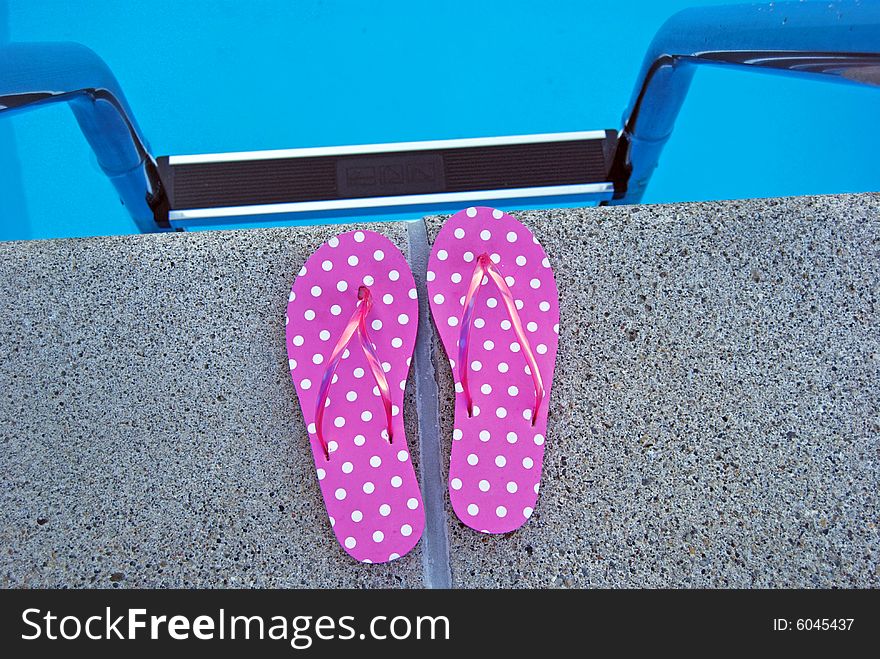 Bright flip-flops at the top of the pool ladder. Bright flip-flops at the top of the pool ladder.
