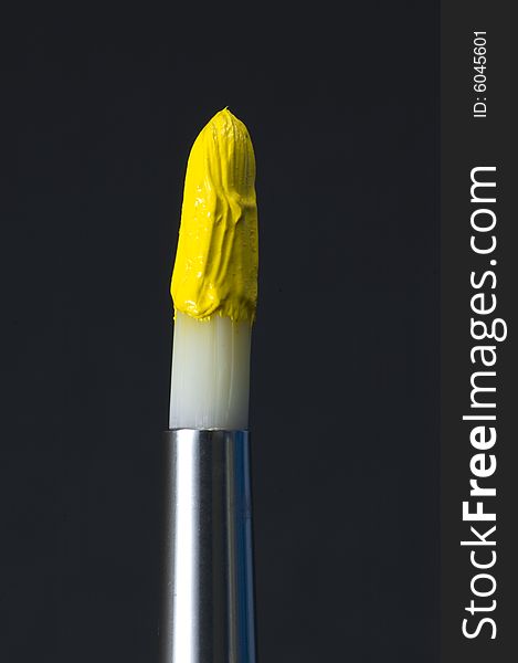 Loaded paint brush with acrylic yellow paint. Loaded paint brush with acrylic yellow paint