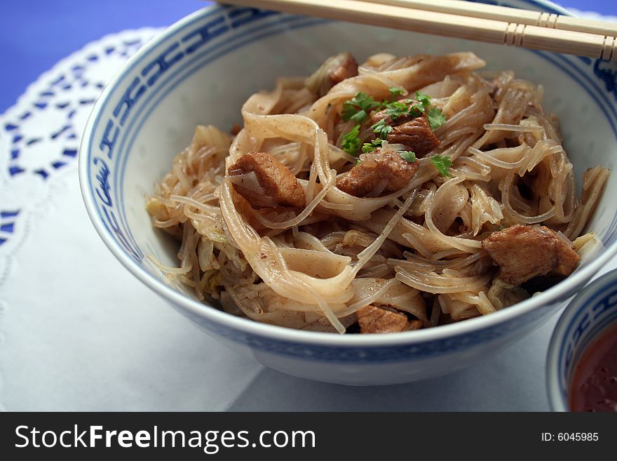 Chinese food with noodles and meat in chinese table-ware