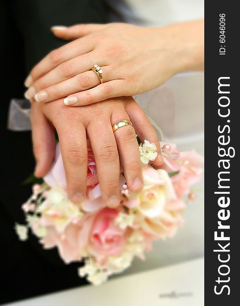 Hands of bride and groom with rings on bouquet. Hands of bride and groom with rings on bouquet.