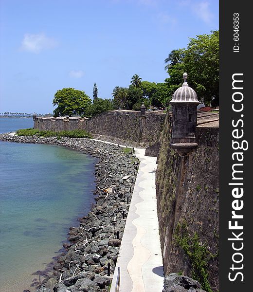 The view of the alley along the wall of historic San Felipe del Morro fort in the old town of San Juan, the capital of Puerto Rico. The view of the alley along the wall of historic San Felipe del Morro fort in the old town of San Juan, the capital of Puerto Rico.