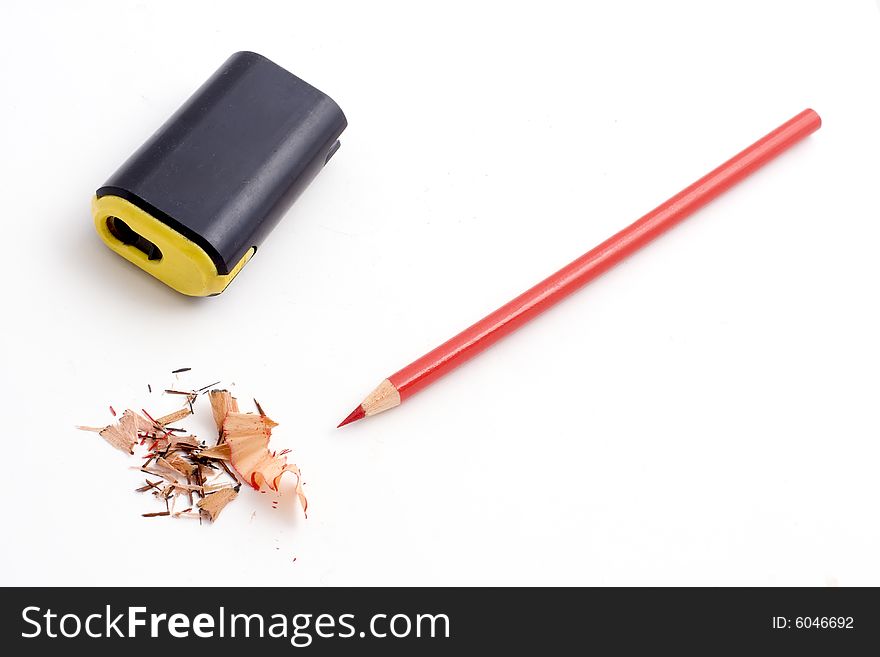 Colored pencil, sharpener, and pencil shavings isolated on a white background. Colored pencil, sharpener, and pencil shavings isolated on a white background