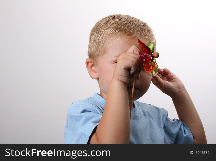 Toddler hiding behind his foil wind fan. Toddler hiding behind his foil wind fan