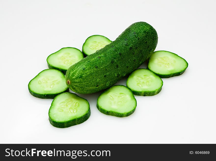 Fresh cucumber and slices on white with water drops