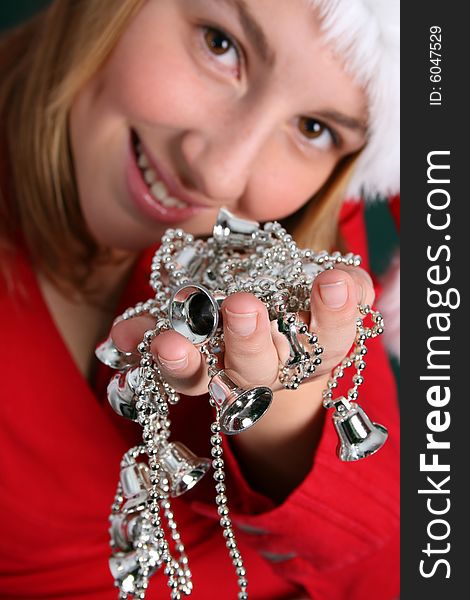Teenager in red holding a string of silver Christmas Decorations