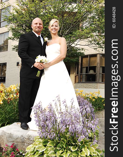 An just married couple standing on a big rock for photo shoots. An just married couple standing on a big rock for photo shoots.