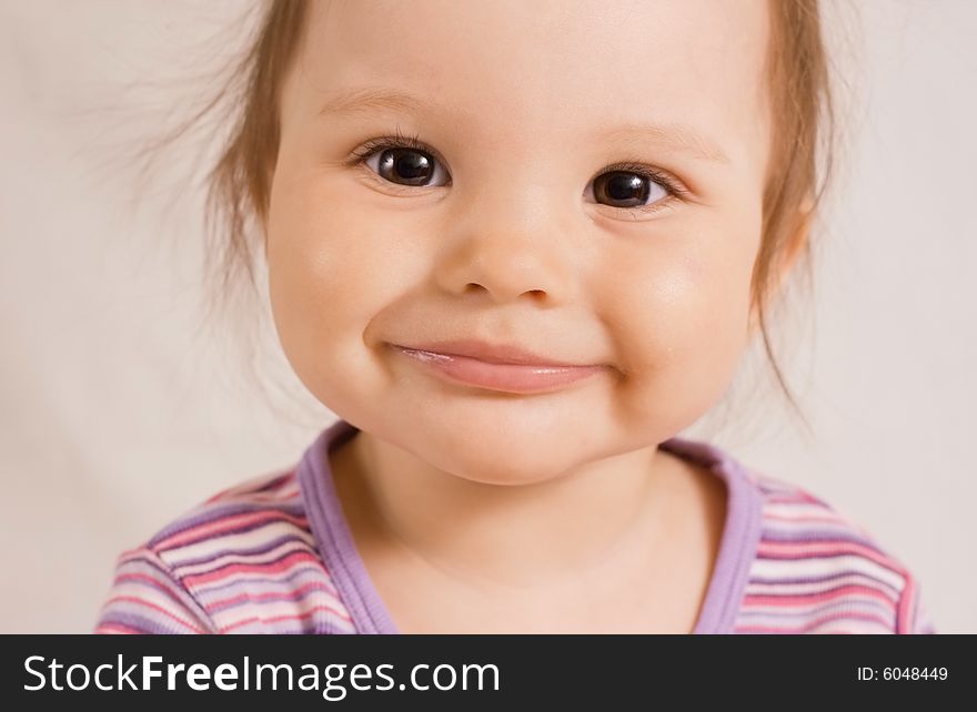 Small joyful smiling girl in rose shirt