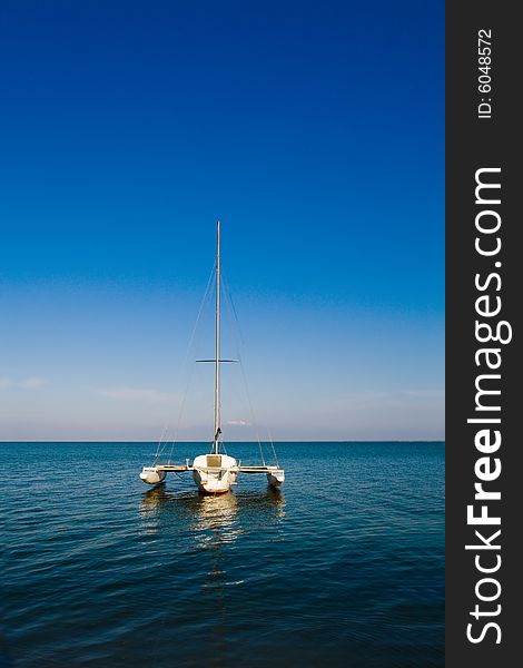 Lonely boat floating on blue calm see. Lonely boat floating on blue calm see