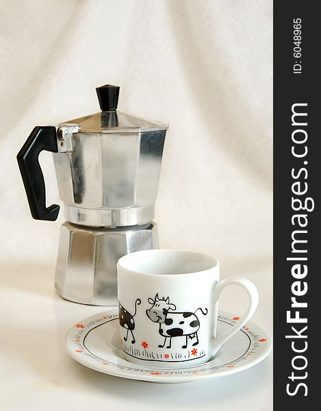 White cup with picture of cow against coffee-maker. White cup with picture of cow against coffee-maker