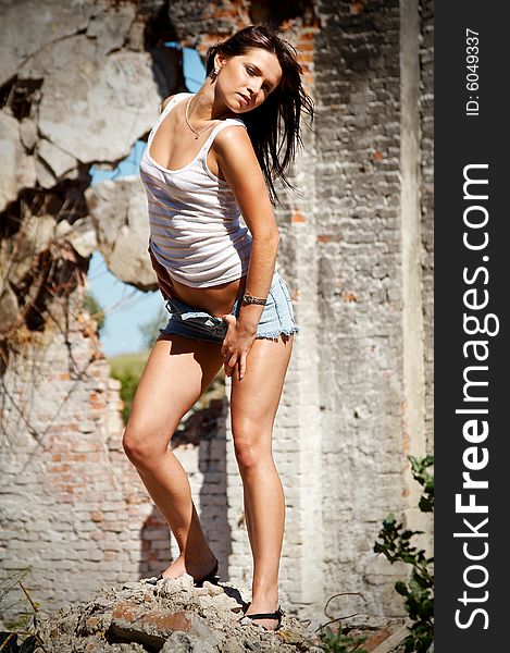 Young sexy woman in jeans shorts at old factory. Young sexy woman in jeans shorts at old factory