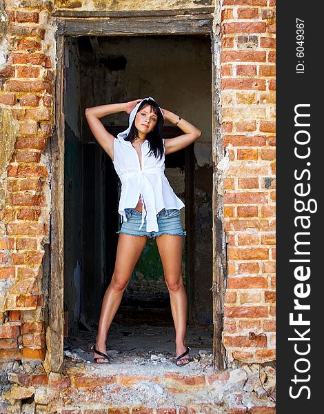 Attractive lady in a doorway of old structure