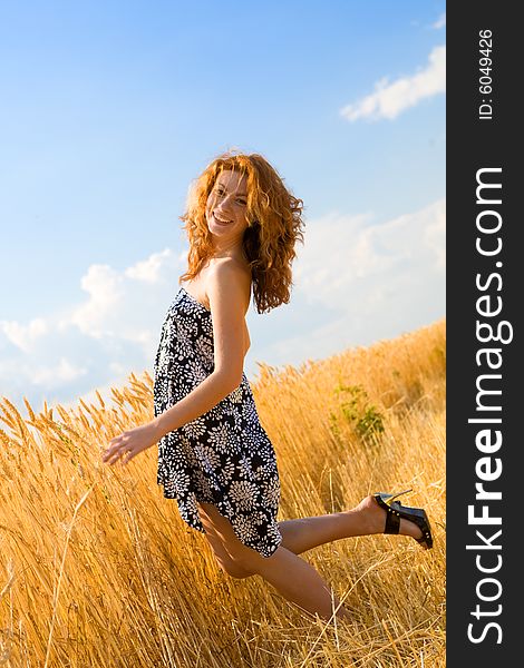 Beautiful caucasian girl standing in the golden wheat field. Beautiful caucasian girl standing in the golden wheat field