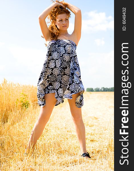 Beautiful caucasian girl standing in the golden wheat field. Beautiful caucasian girl standing in the golden wheat field