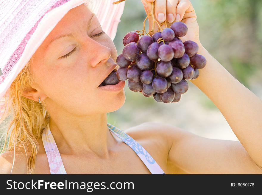 Young girl eating blue grapes