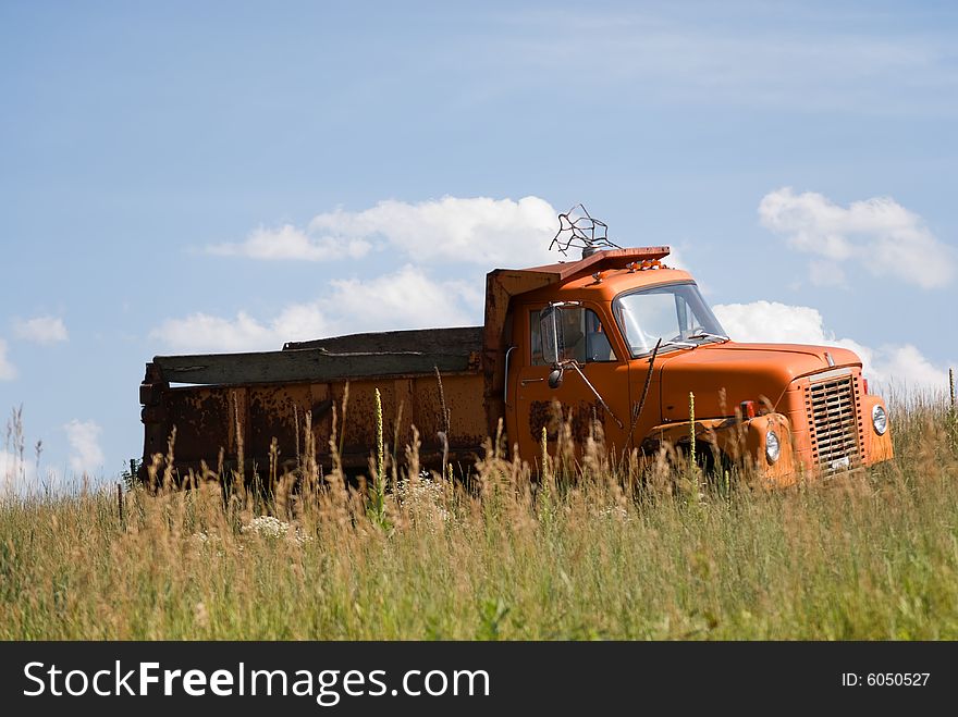 Old run-down pick-up truck abandoned in a field