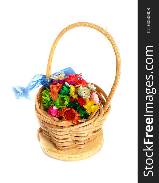 Artificial colorful flowers in a basket on a white background