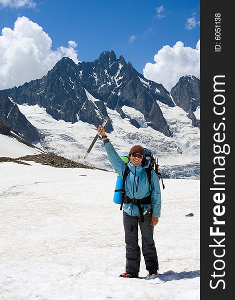 Smiling backpacker woman with ice-axe