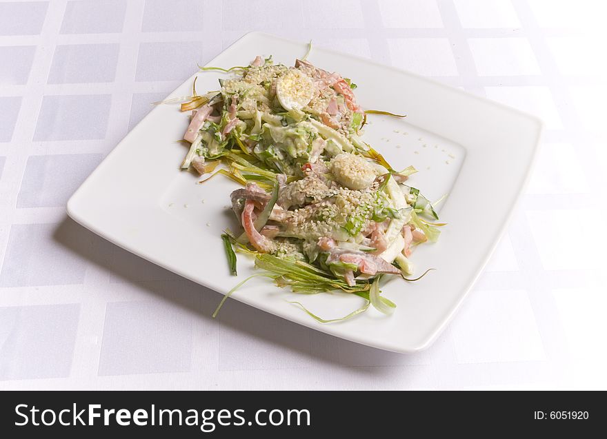 Salad with ham, eggs and herbs on white plate. Salad with ham, eggs and herbs on white plate