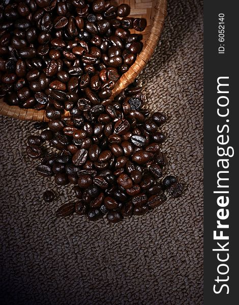 Coffee bean on the rattan dish on the dark background