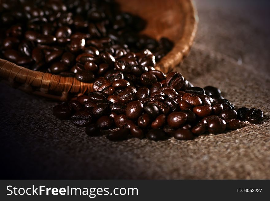 Coffee bean on the rattan dish on the dark background