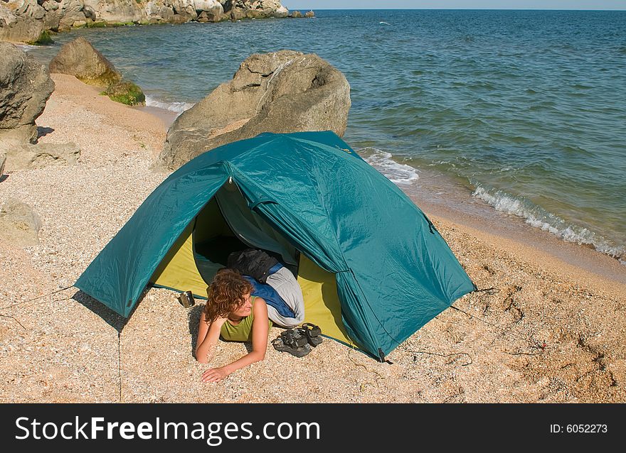 Tent on sea beach and girl near of it