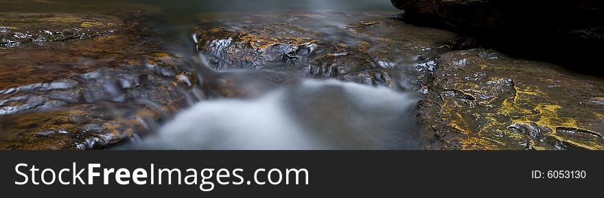 Pano stitch of rocks in a waterfall, with water creating misty effect. Pano stitch of rocks in a waterfall, with water creating misty effect.