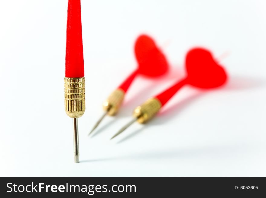 Three red darts close-up on a white surface