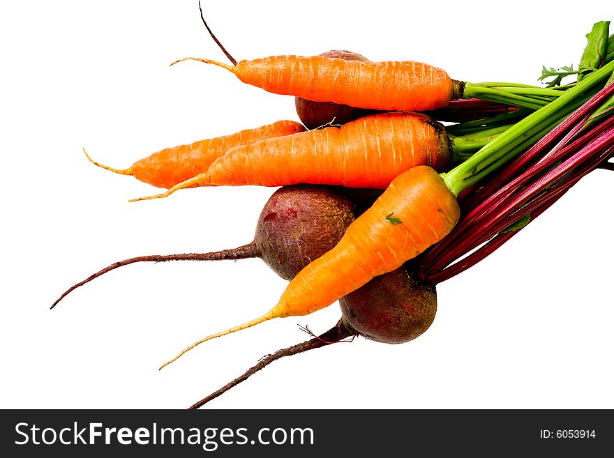 An image of fresh beets and carrots with green leaves. An image of fresh beets and carrots with green leaves