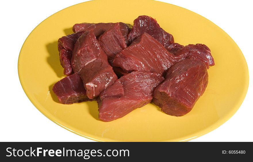 Pieces of raw beef on yellow plate
