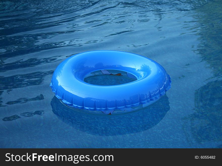 A blue inflatable wheel or tire is floating in the pool