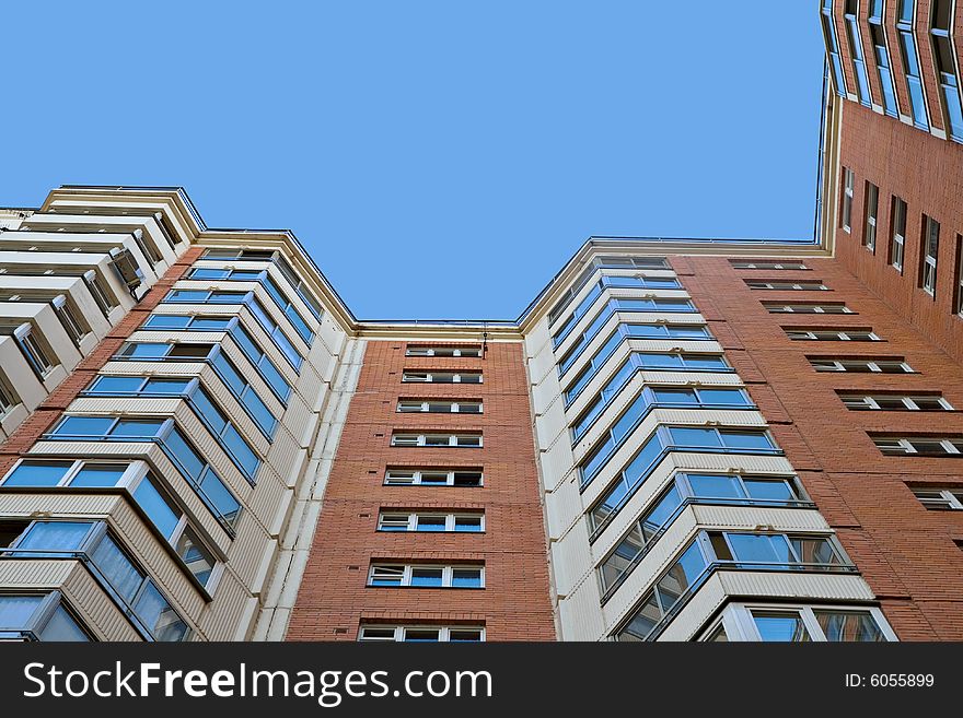 A residential multistory house and sky, view from below. A residential multistory house and sky, view from below