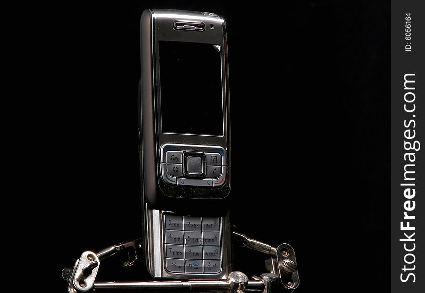 New cellphone in metal holder with black background. New cellphone in metal holder with black background