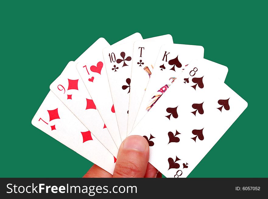 Hand with playing cards isolated over a green background