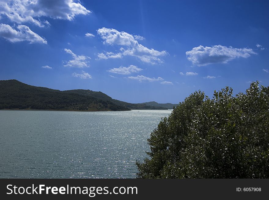 Lake in mountain with blue sky and fluffy white clouds