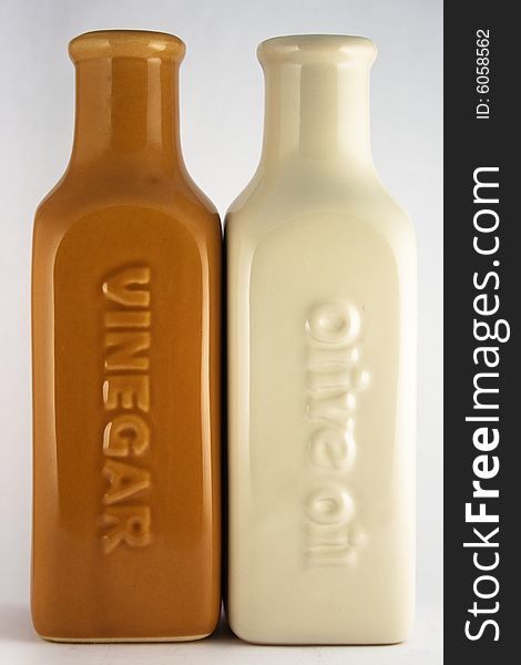 A white oil and red vinegar bottle next to each other. A white oil and red vinegar bottle next to each other.