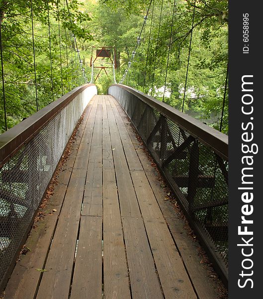 Suspension bridge crossing a river in the forest. Suspension bridge crossing a river in the forest.