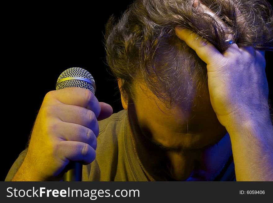 Passionate Vocalist with Microphone on a black background. Passionate Vocalist with Microphone on a black background.