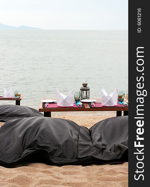 Romantic table setting on a sandy beach.