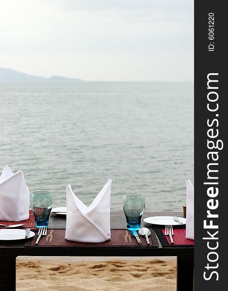 Romantic table setting on a sandy beach.