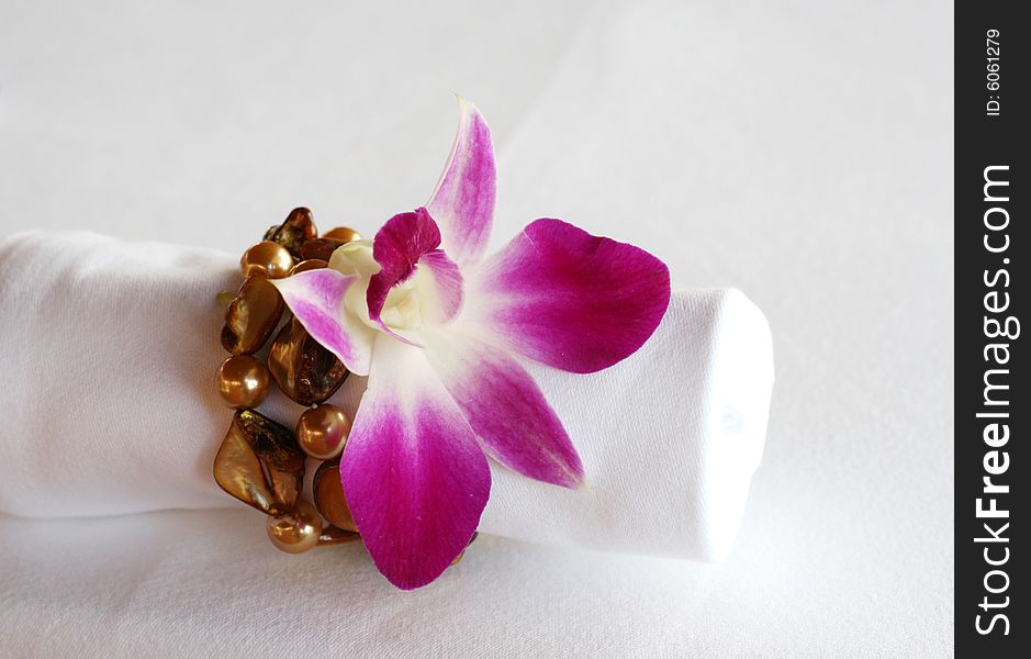 White napkin decorated with an orchid and precious stones. White napkin decorated with an orchid and precious stones.