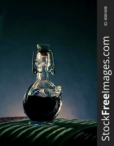 A small glass bottle on a smooth background. A small glass bottle on a smooth background