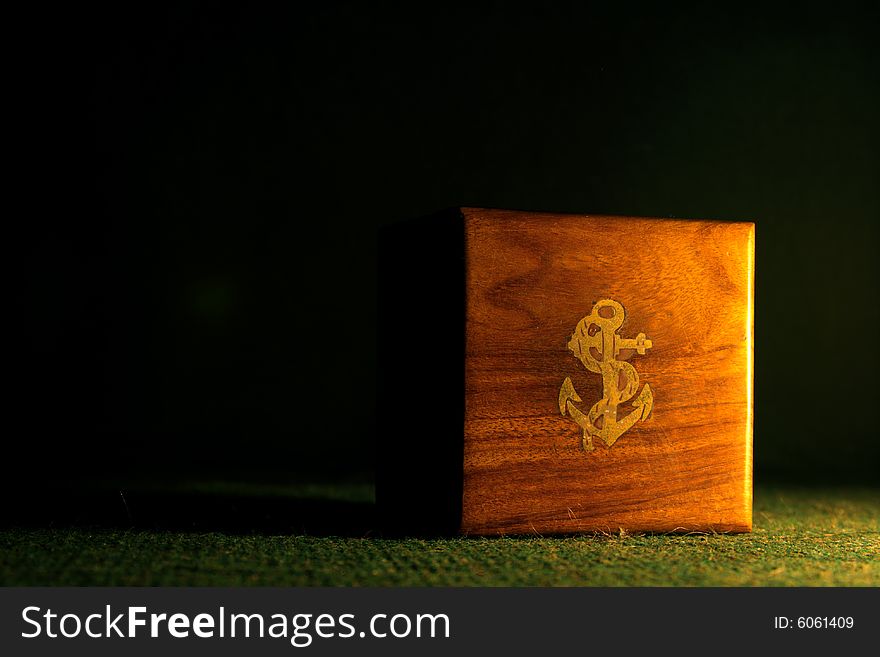 A small wooden box with an anchor sign. A small wooden box with an anchor sign