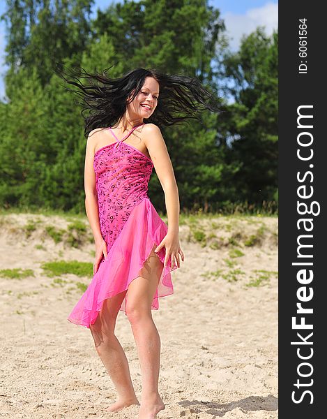 Beautiful happy woman dancing on the beach